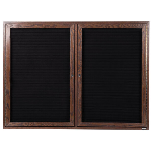 A black framed wooden cabinet with black felt message board doors.
