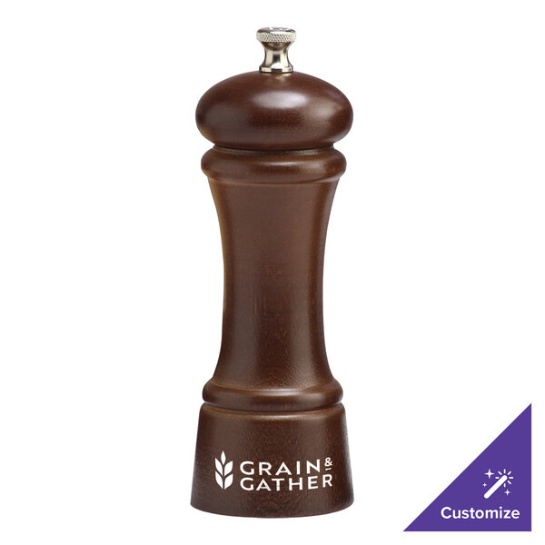 A brown walnut pepper mill with a silver top.