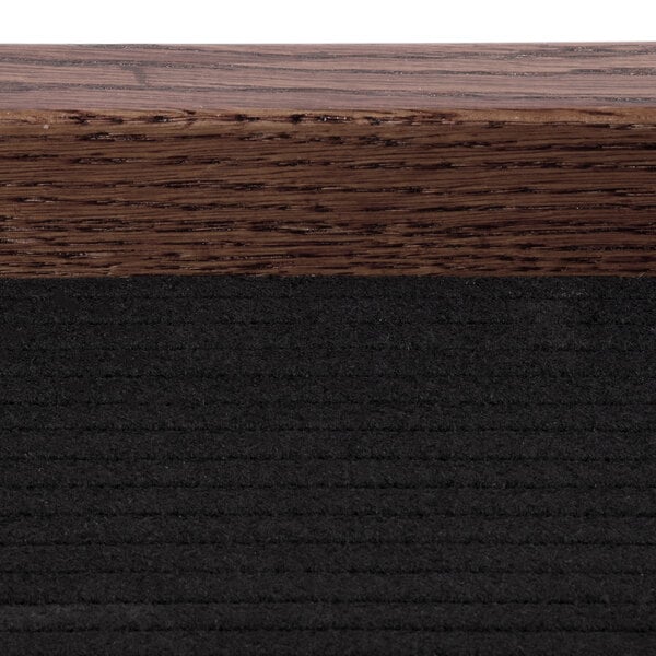 A close up of the walnut wood grain on a door with black trim.
