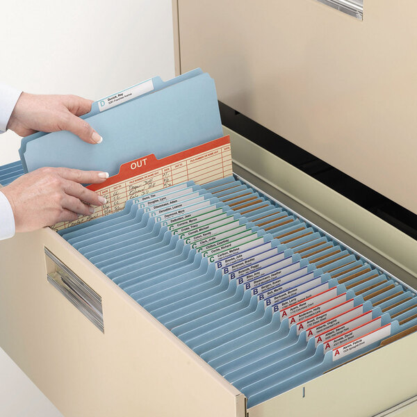 A person opening a file drawer filled with Smead SafeSHIELD letter size classification folders.