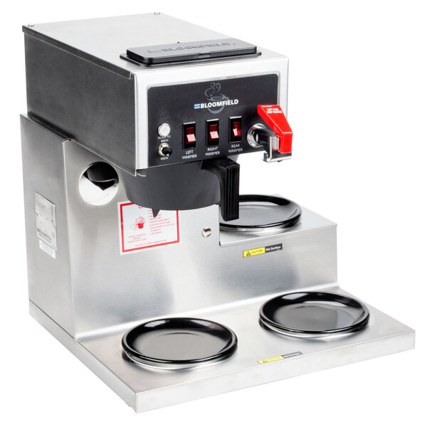 A silver Bloomfield automatic coffee brewer with three black warmers.