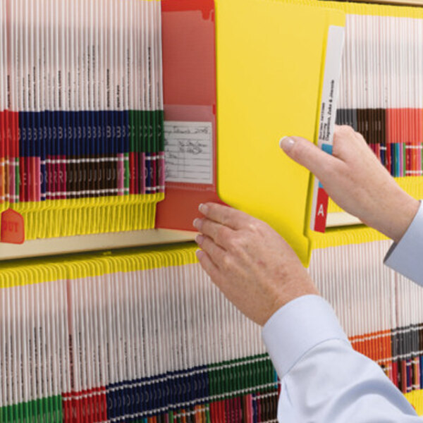A person holding a Smead yellow Shelf-Master file folder.