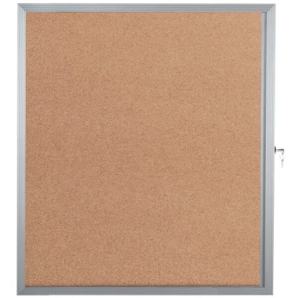 An Aarco cork bulletin board with a silver frame and key lock.