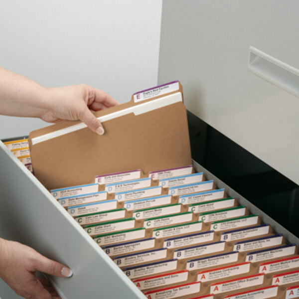 A hand putting Smead file folders in a file drawer.