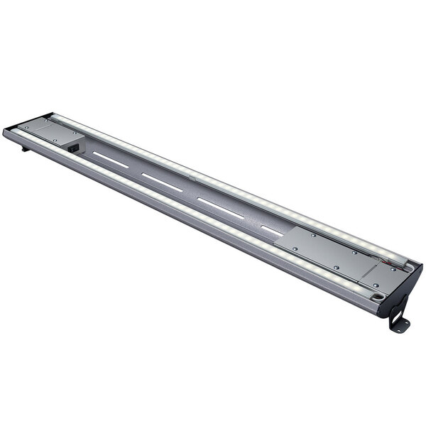A long rectangular metal light fixture with curved lights on the bottom.