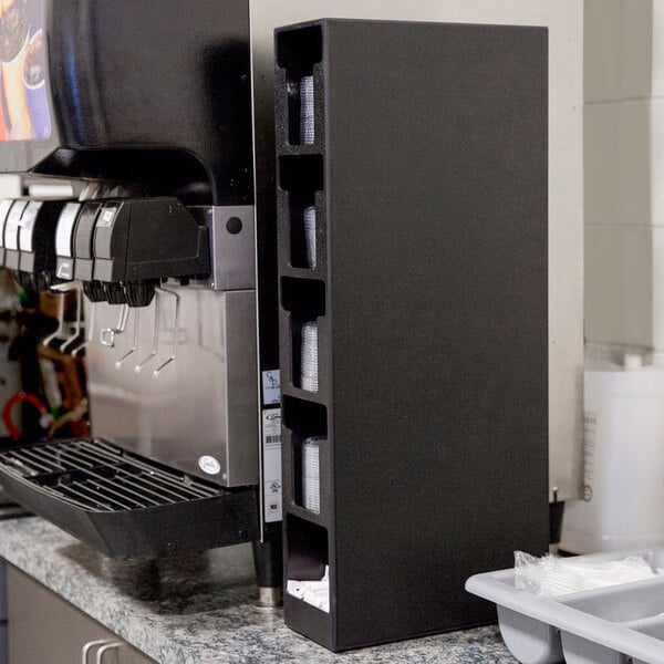 A black Vollrath countertop lid organizer with straw pocket.