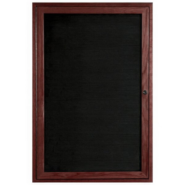 An Aarco enclosed black message board with a cherry frame.