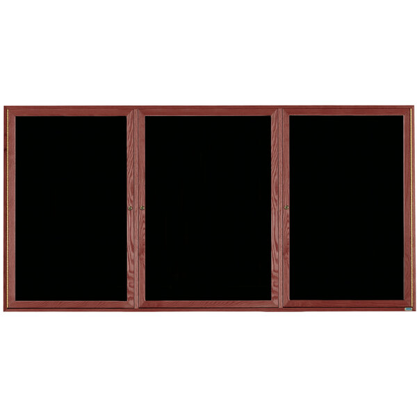 A black board with a wooden frame and three black glass doors.