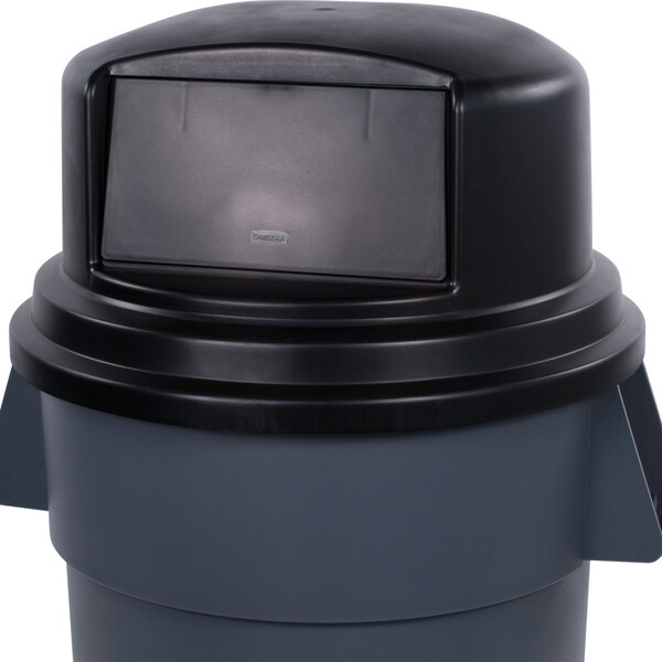 A black Carlisle Bronco dome top lid on a grey trash can.