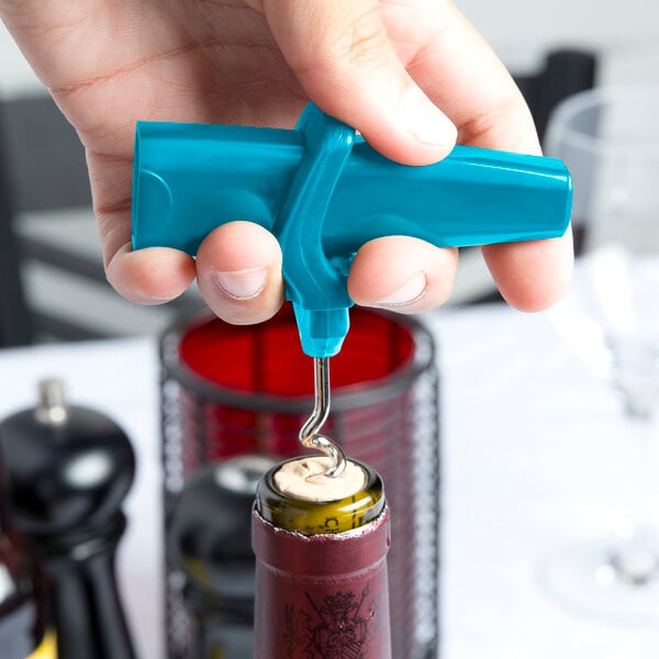A hand holding a Franmara turquoise plastic corkscrew over a wine bottle.