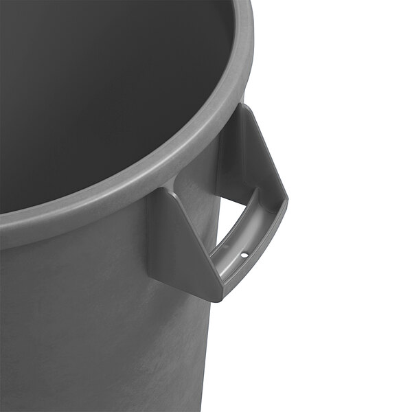 A close-up of a Carlisle gray round trash can with a handle on top.