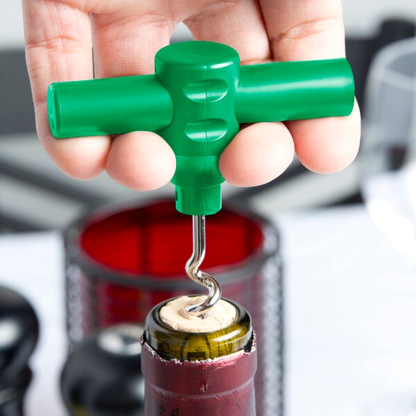 A hand holding a Franmara green plastic pocket corkscrew with a wine bottle opener.