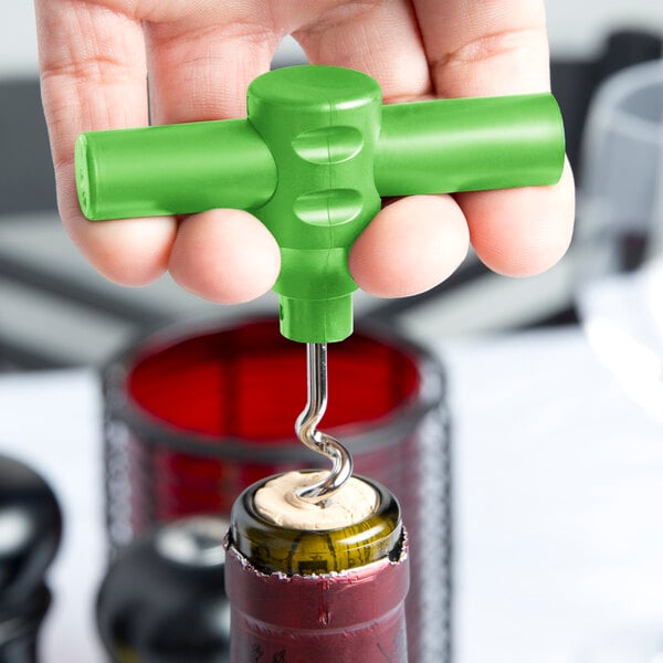 A person using a Franmara green plastic pocket corkscrew to open a wine bottle.