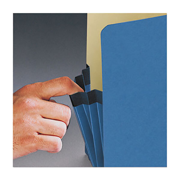 A hand holding a blue Smead file pocket with a straight cut tab.