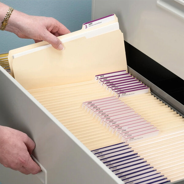 A person opening a file drawer with Smead file folders.