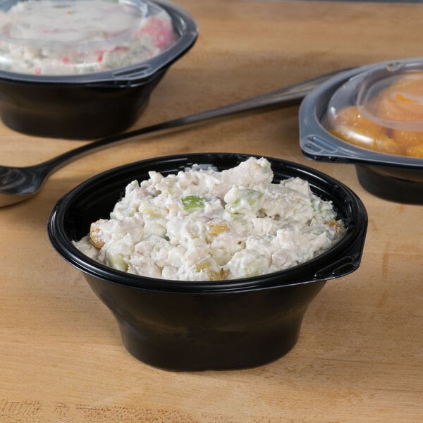 Two Fabri-Kal black plastic SideKicks bowls with food in them.