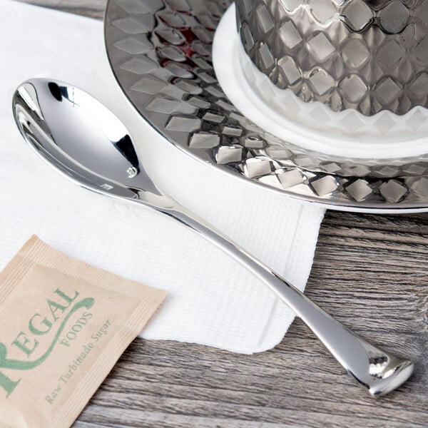 A Chef & Sommelier stainless steel teaspoon on a plate.