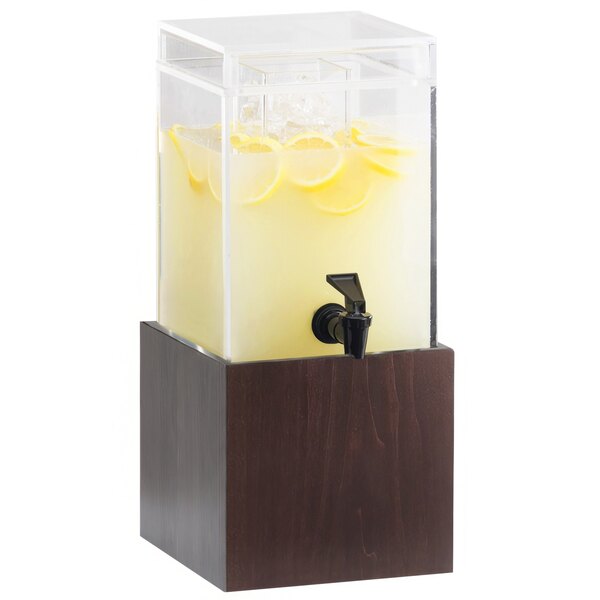 A Cal-Mil dark wood beverage dispenser with a black spigot filled with lemonade and lemons.