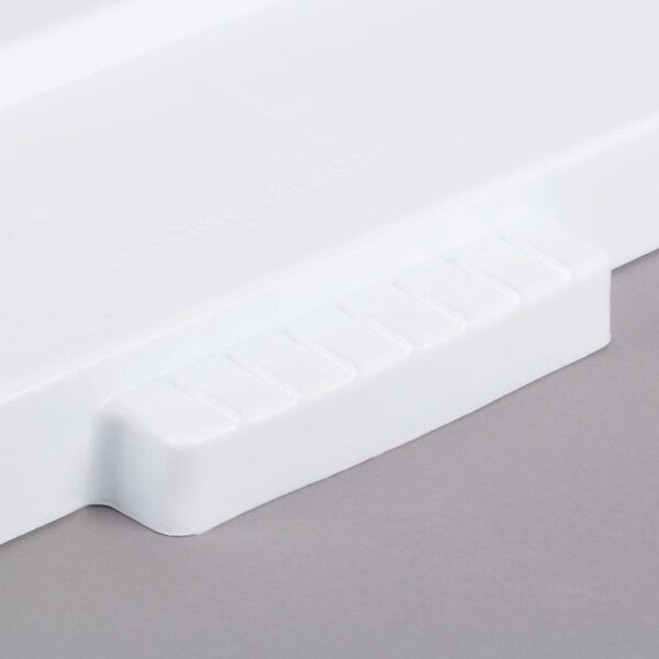 A white plastic lid with a handle for a Rubbermaid BRUTE container.