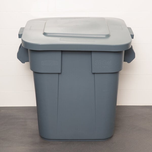 A Rubbermaid gray plastic square trash can with a lid.