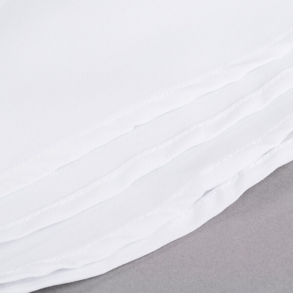 A stack of Intedge white cloth table covers.