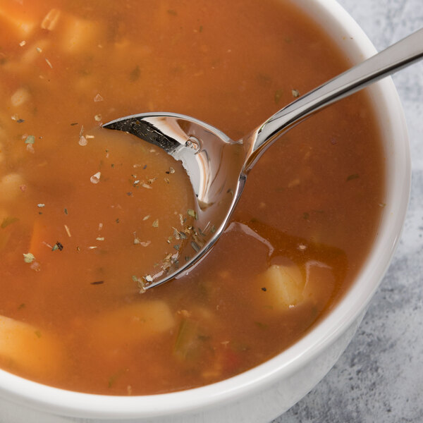 A bowl of soup with a Chef & Sommelier Renzo stainless steel soup spoon in it.