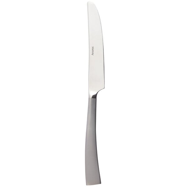 An Arcoroc stainless steel dinner knife with a silver handle.