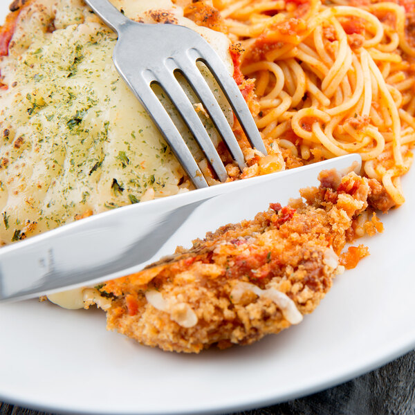 A plate of food with a Libbey Kings stainless steel dinner knife and fork.