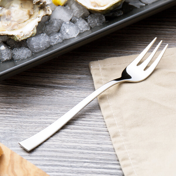 A fork is on a napkin on a table.