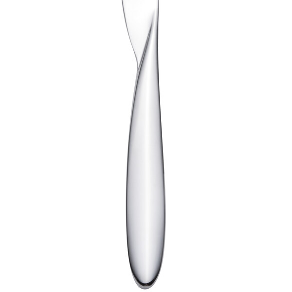 An Arcoroc stainless steel dinner knife with a white handle.