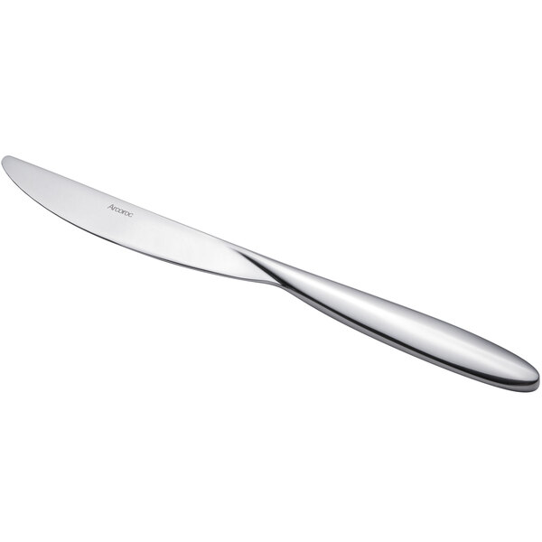 An Arcoroc stainless steel dinner knife with a silver handle.