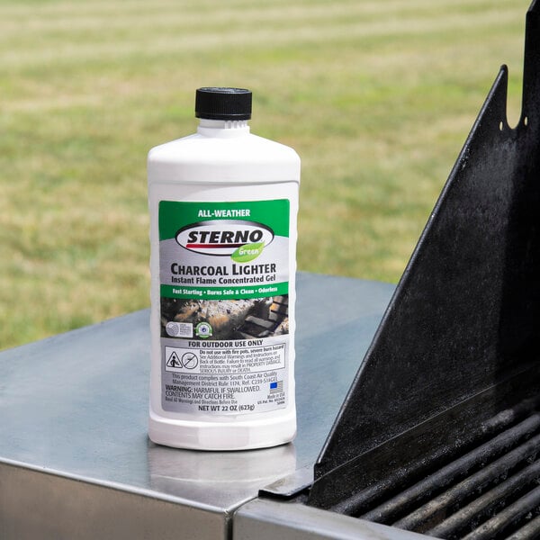 A white bottle of Sterno All-Weather Charcoal Lighter Gel on a grill.