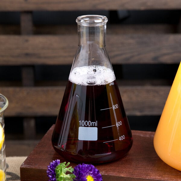 An American Metalcraft glass Erlenmeyer flask filled with brown liquid on a table.