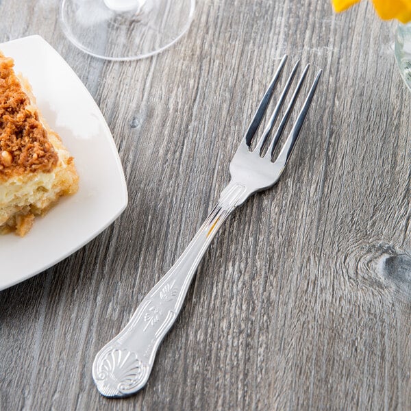 A Libbey stainless steel dinner fork on a plate of food.