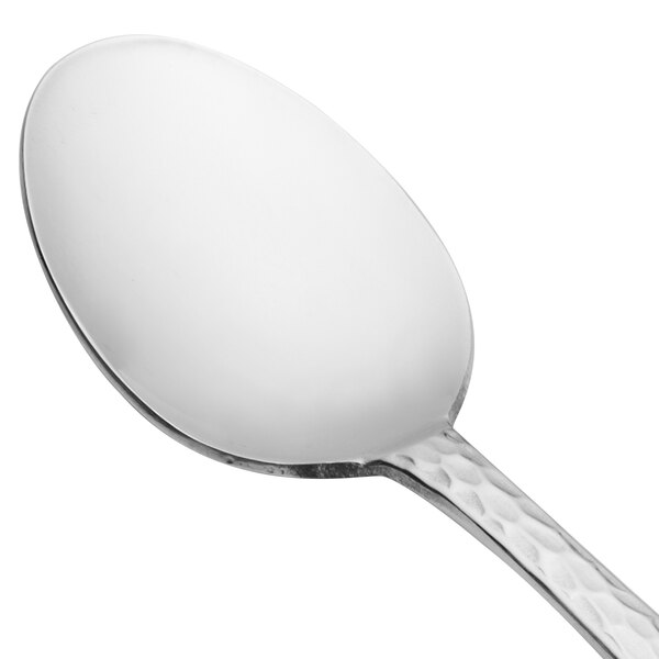 A Libbey stainless steel dessert spoon with a white handle and silver rim.