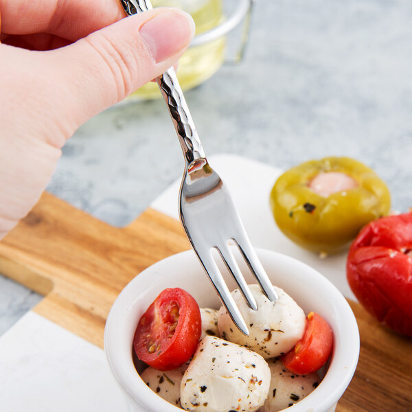 A Libbey stainless steel cocktail fork in a bowl of mozzarella cheese and tomatoes.