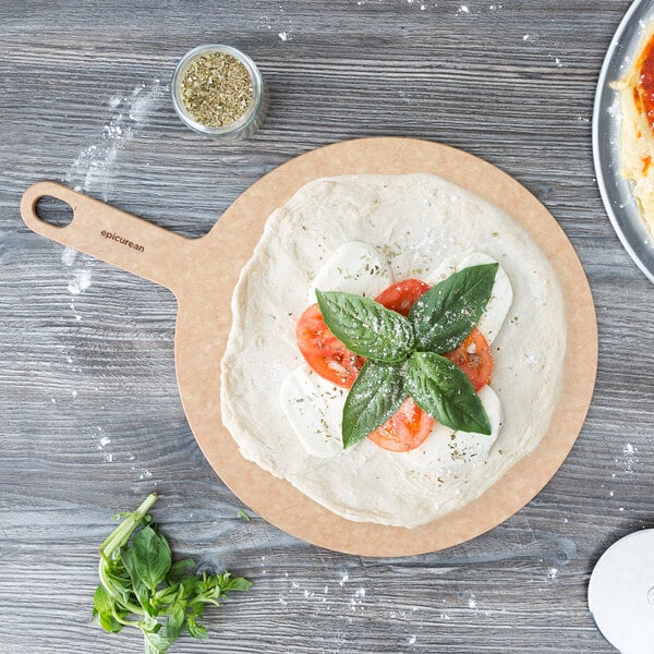 A pizza with tomatoes, basil, and cheese on an Epicurean wood pizza board.