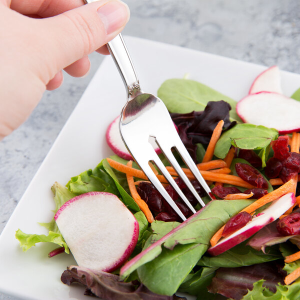A Libbey Lady Astor stainless steel salad fork in a vegetable salad.
