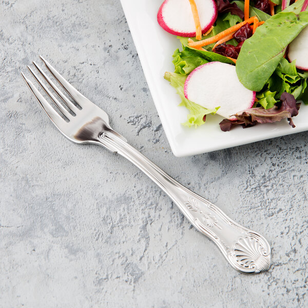 A Libbey stainless steel salad fork on a plate of salad.