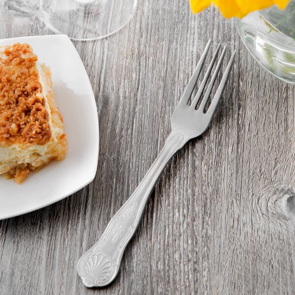 A Libbey stainless steel utility fork on a plate of food.