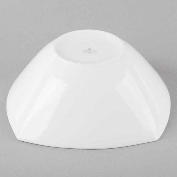 A Schonwald white square porcelain bowl on a gray surface.