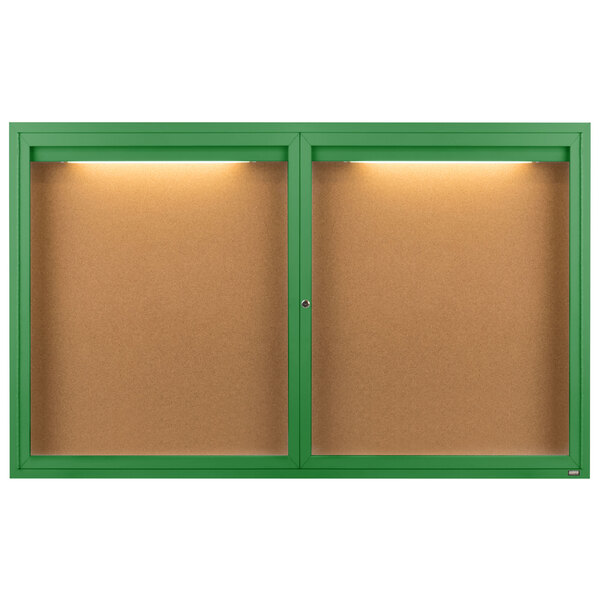 Two green enclosed bulletin boards with lights on the frames.