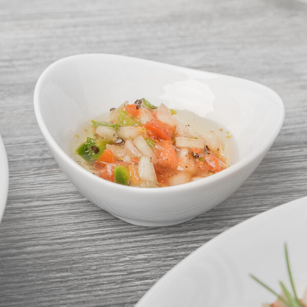 A Schonwald Grace white porcelain dip dish filled with food on a table.