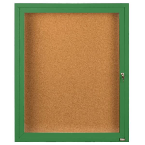 A green framed Aarco bulletin board with a green door.