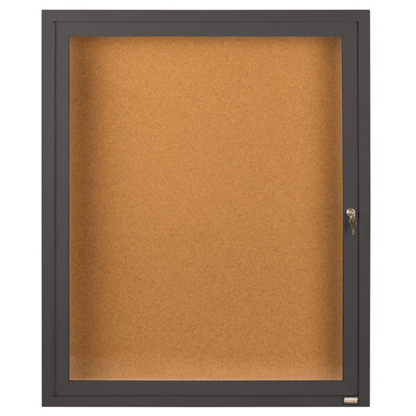 A bronze Aarco bulletin board cabinet with a key-locked glass door.