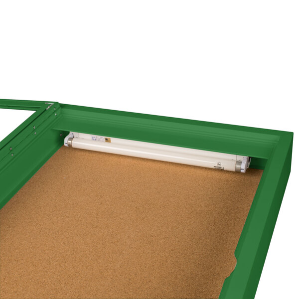 A green rectangular Aarco bulletin board cabinet with a light inside.