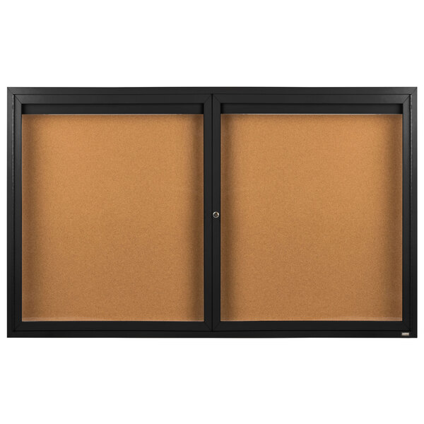 A brown Aarco bulletin board cabinet with black doors.