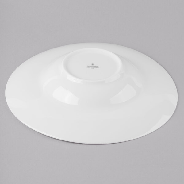 A Schonwald Grace porcelain pasta bowl with a circular rim on a gray surface.