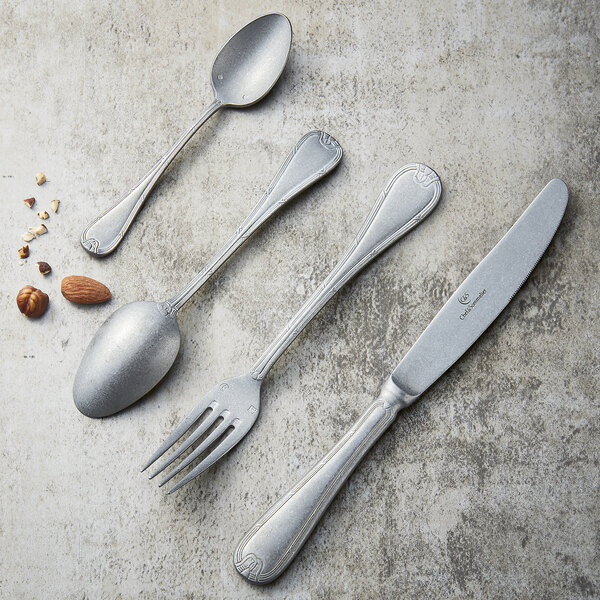 A Chef & Sommelier stainless steel dinner fork on a table with nuts.
