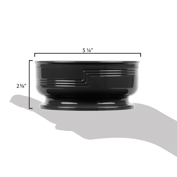 A person holding a small black bowl.